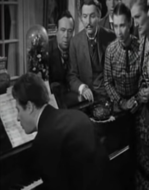Александр Белл демонстрирует явление акустического резонанса гостям (кадр из фильма «Alexander Graham Bell» 1939 года).png